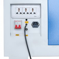 На белой панели корпуса станка размещены блок из трех универсальных розеток, автоматический выключатель с красным рычажгом, разъем для кабеля питания и выходящий из отверстия черный силовой кабель.