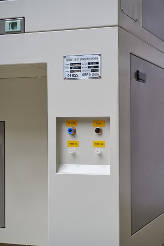 Боковая панель с параметрической табличкой станка (мощность 100W, напряжение 220V), разъемами для воздушного насоса, чиллера и водяного охлаждения
